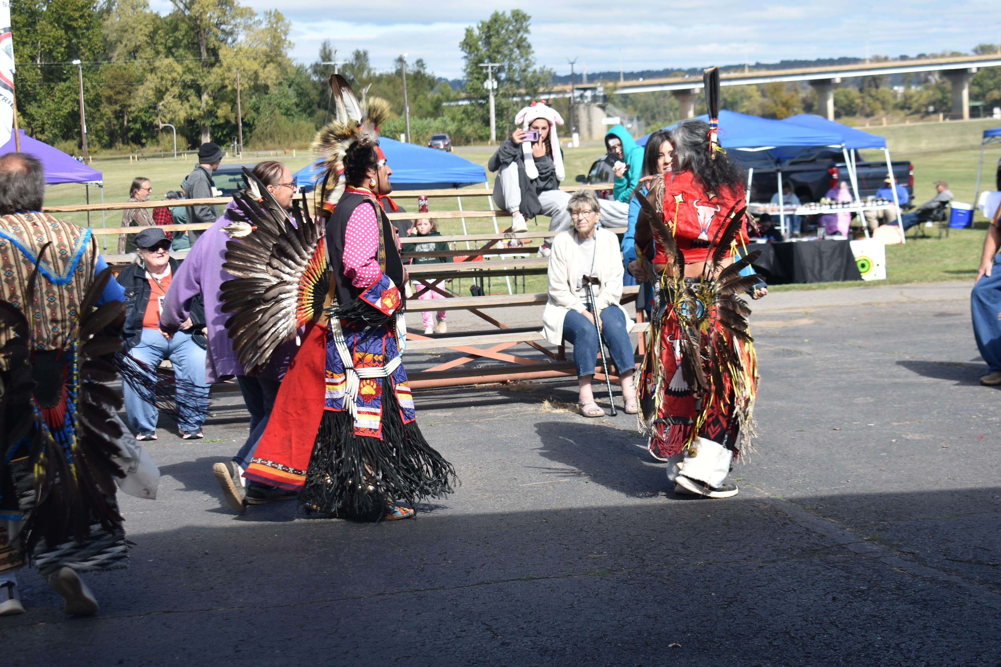 Cherokee dancers moving together in traditional regalia at the festival