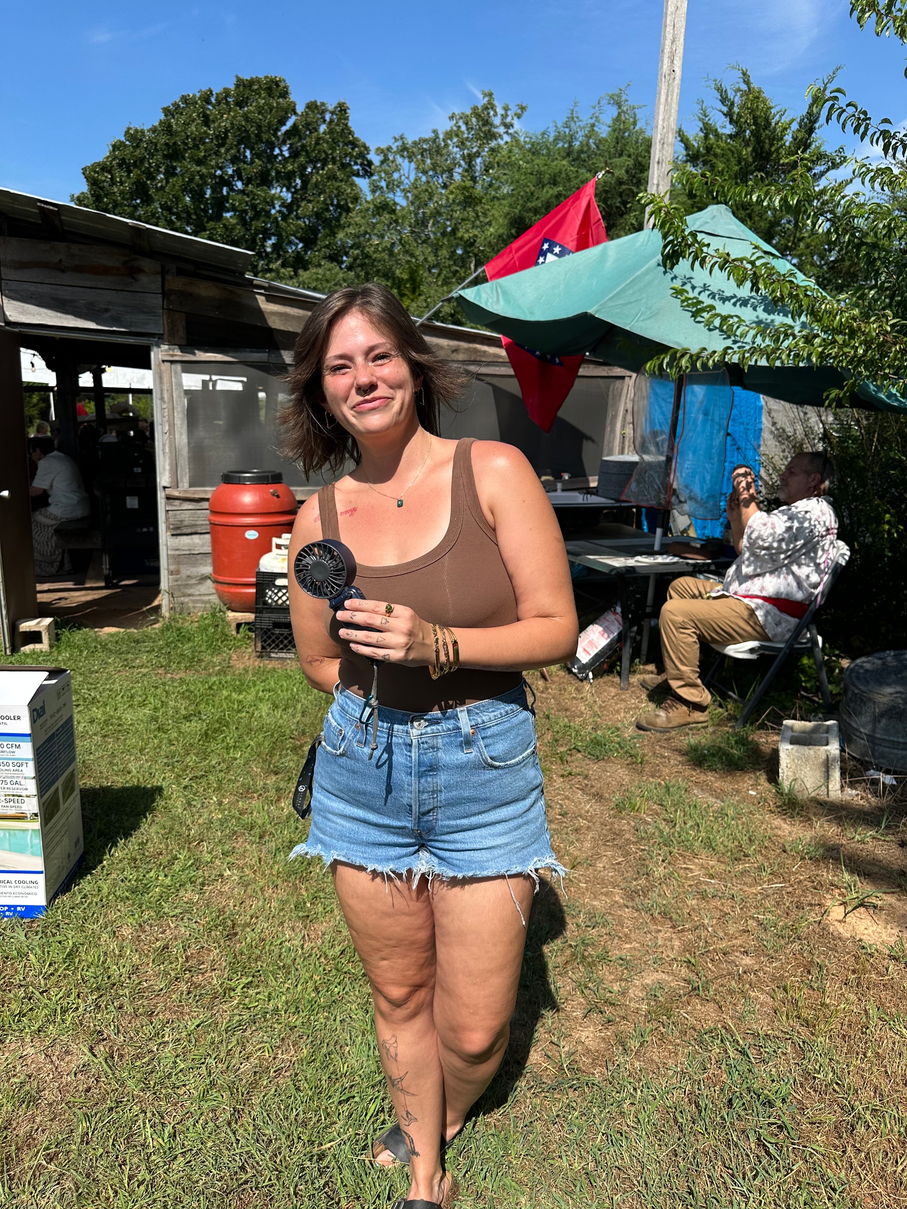 Tribal member smiling outdoors with Arkansas flag at Green Tree Ceremony July 11, 2026