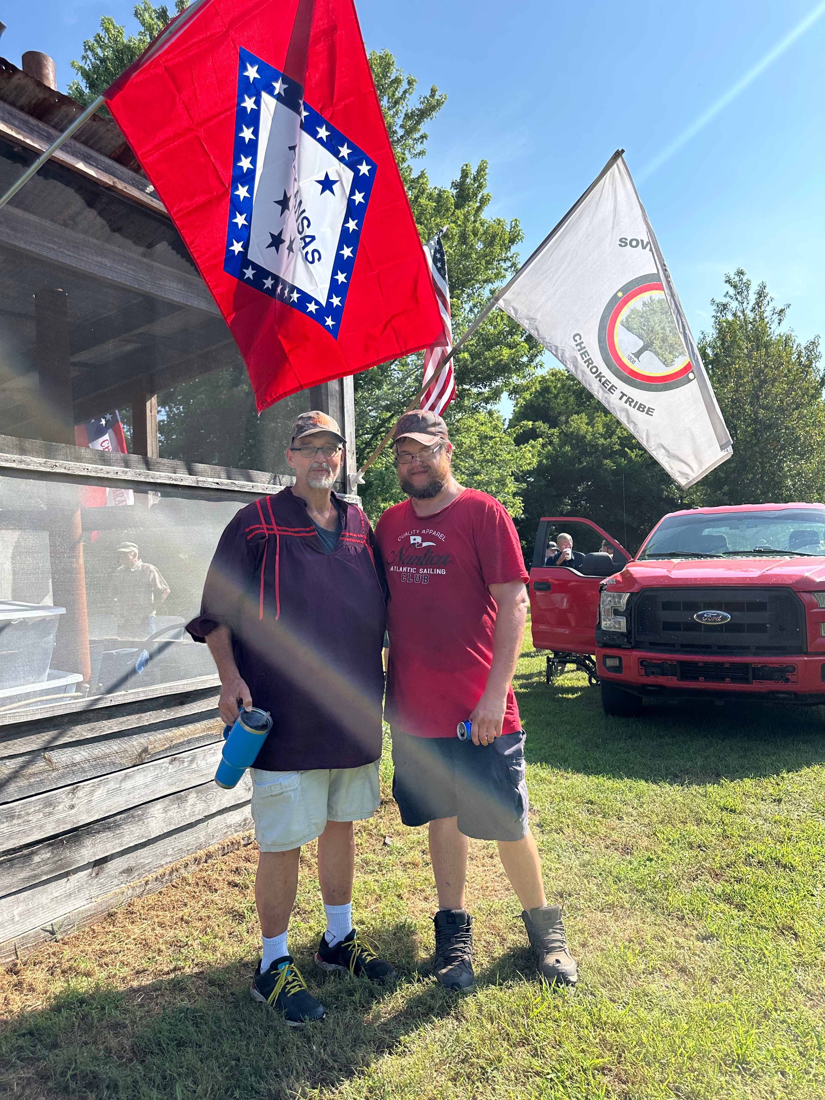 Tribal members with the Sovereign Chickamauga Cherokee Tribe and Arkansas flags at Green Tree Ceremony July 11, 2026