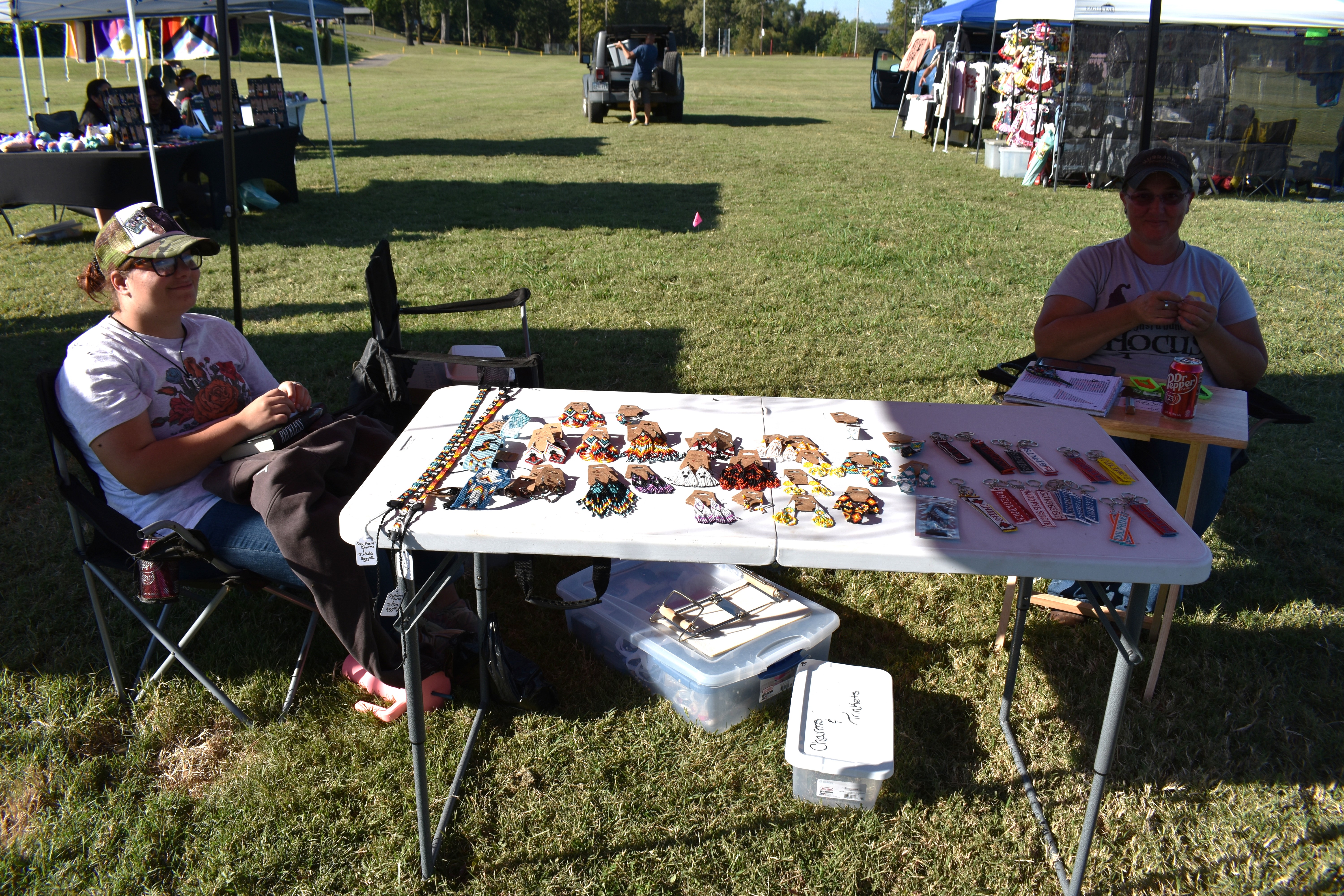Two vendors sitting at a beadwork and jewelry booth at October Festival 2025