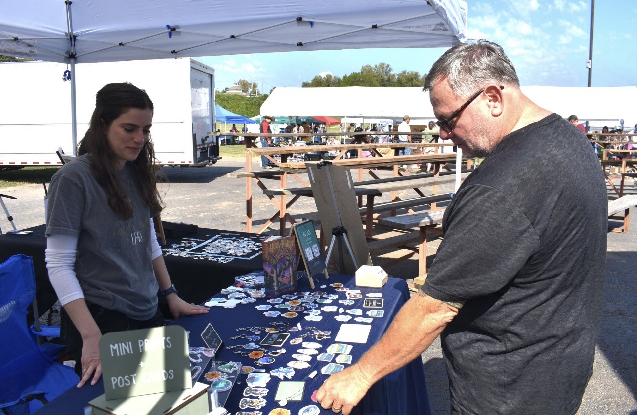 Visitor browsing Cherokee arts and crafts at community event