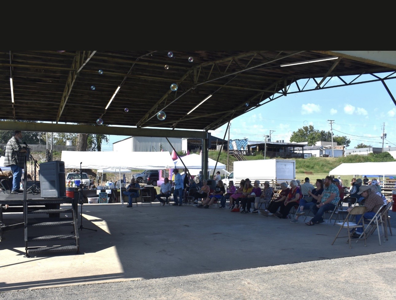 Speaker addressing crowd under pavilion at Cherokee Chickamauga gathering