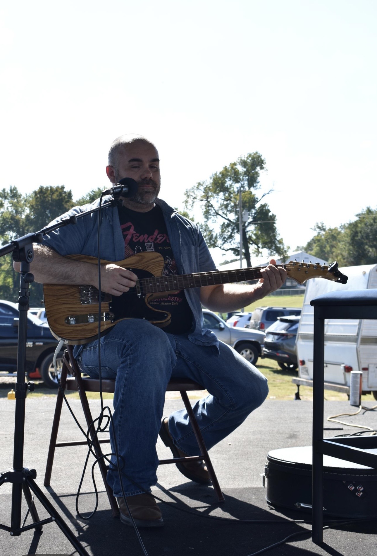 Performer on stage under pavilion with crowd seated at Cherokee Chickamauga gathering