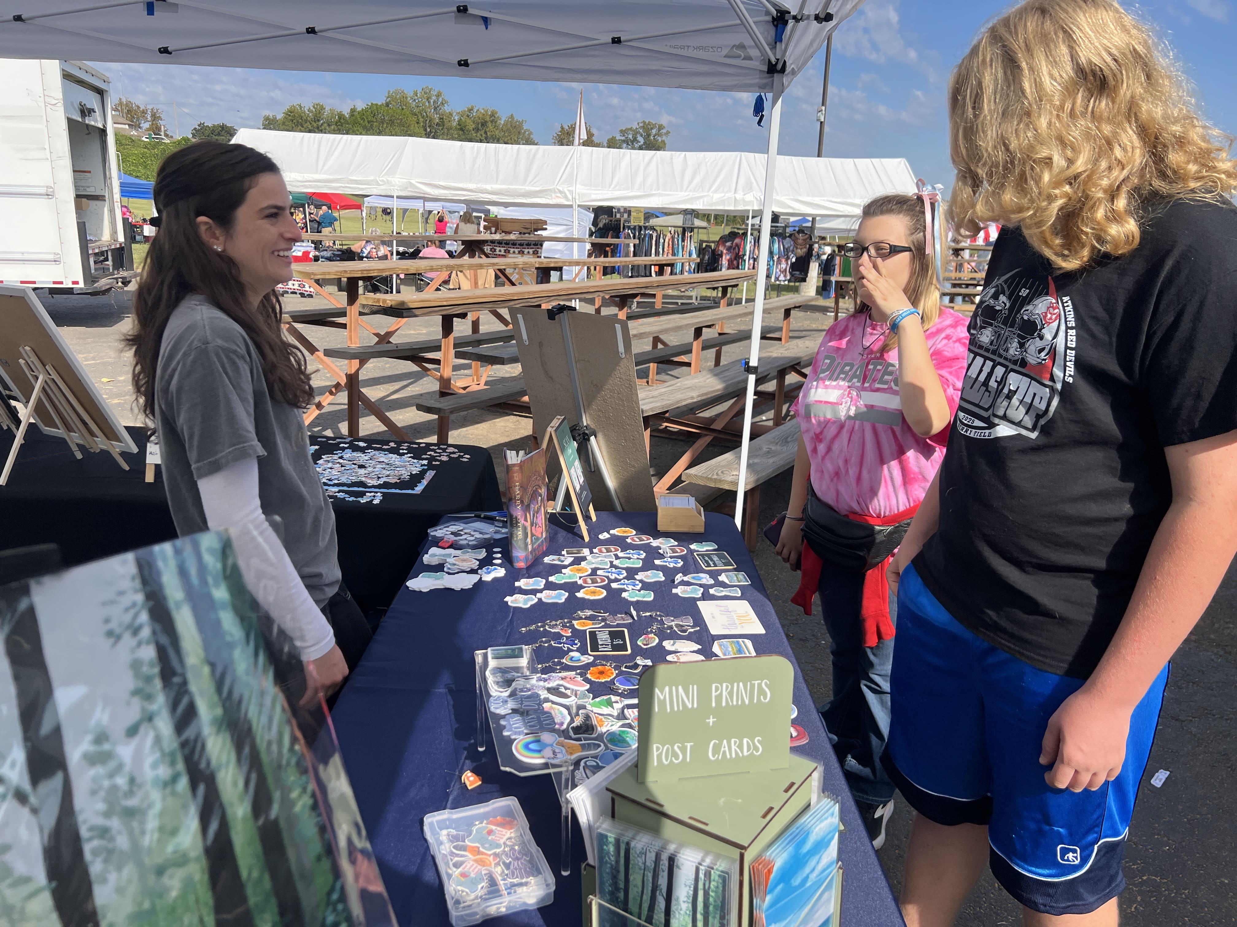Vendor selling mini prints and postcards at October Festival 2025