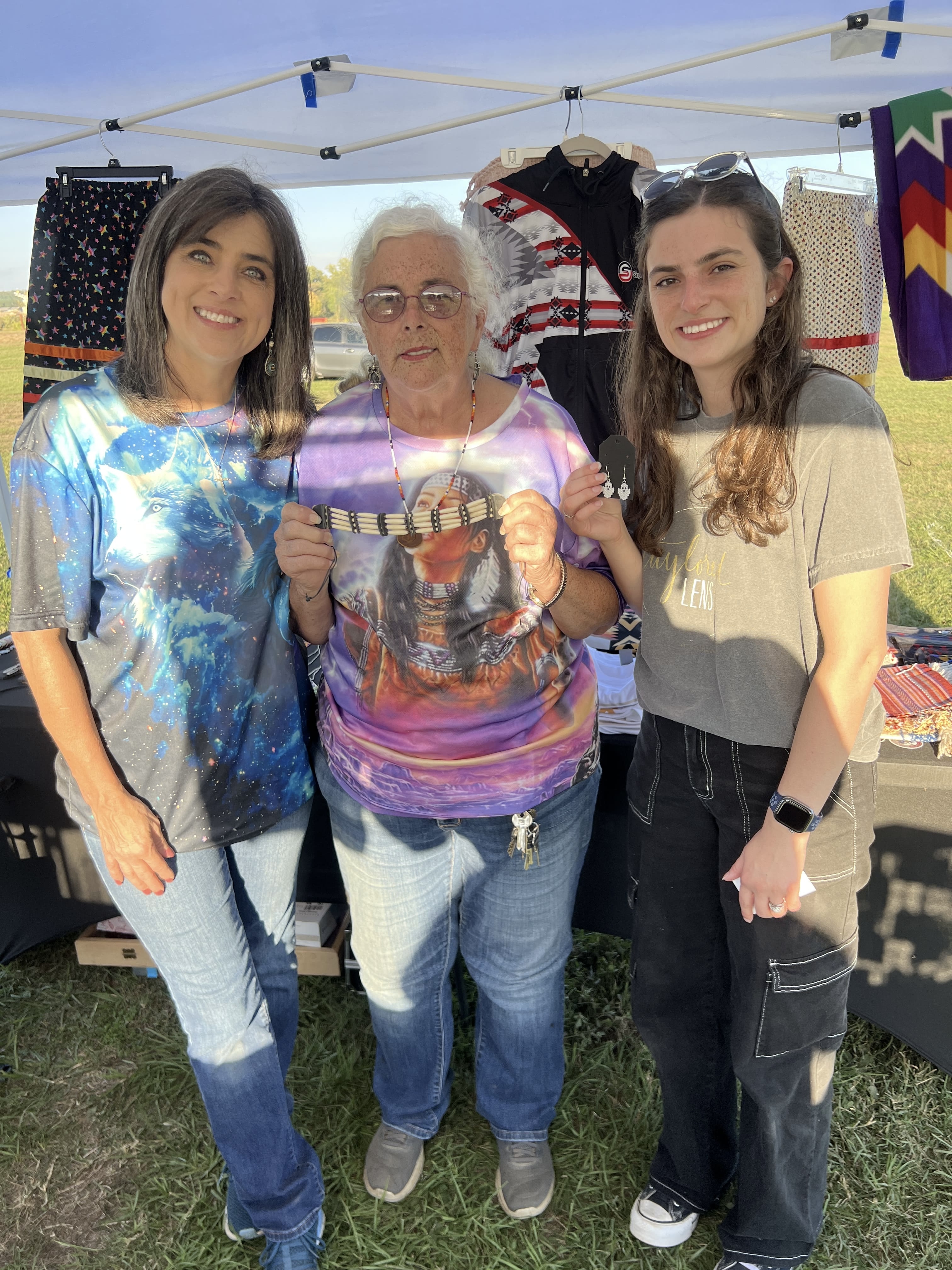 Three women smiling together at October Festival 2025